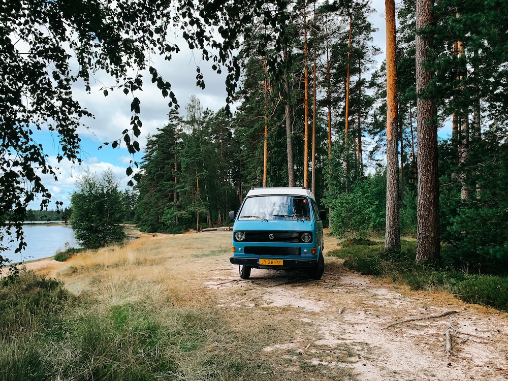 camperbusje op strand aan meer